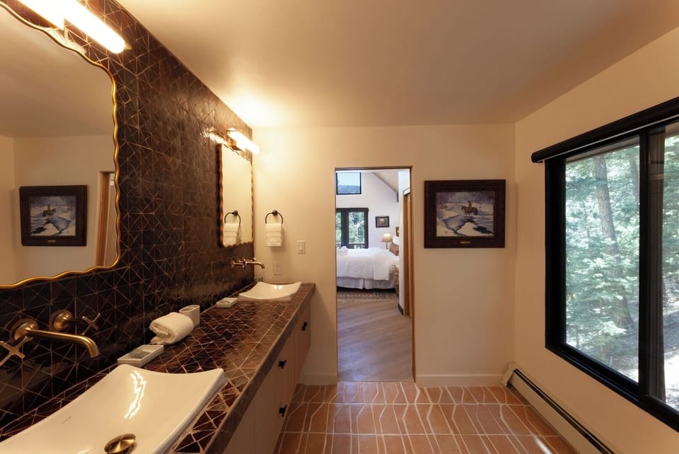 Refresh in a stylish bathroom with elegant geometric tiling, double vanities, and warm lighting that connects to your peaceful bedroom retreat.