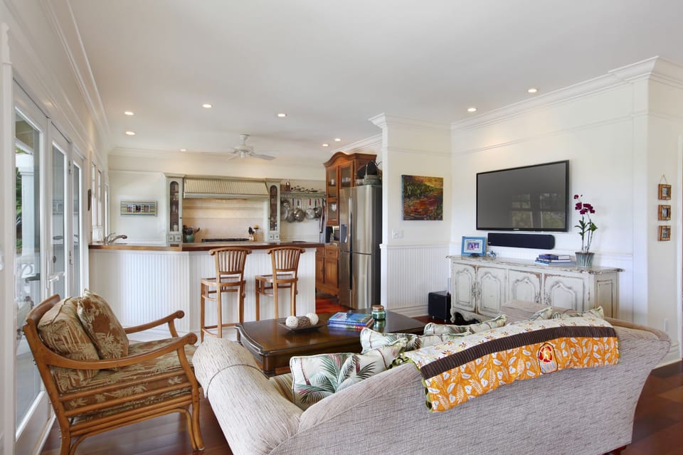 Cozy family room with built-in entertainment, plush seating, and an open kitchen view.