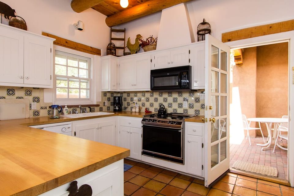 Fully equipped kitchen is complete with coffee maker, cookware, and utensils.