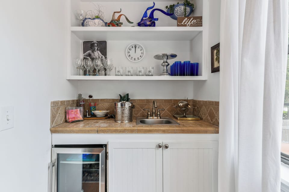 Your private kitchenette features charming open shelving, a built-in sink, and everything you need for light refreshments and easy entertaining during your stay.