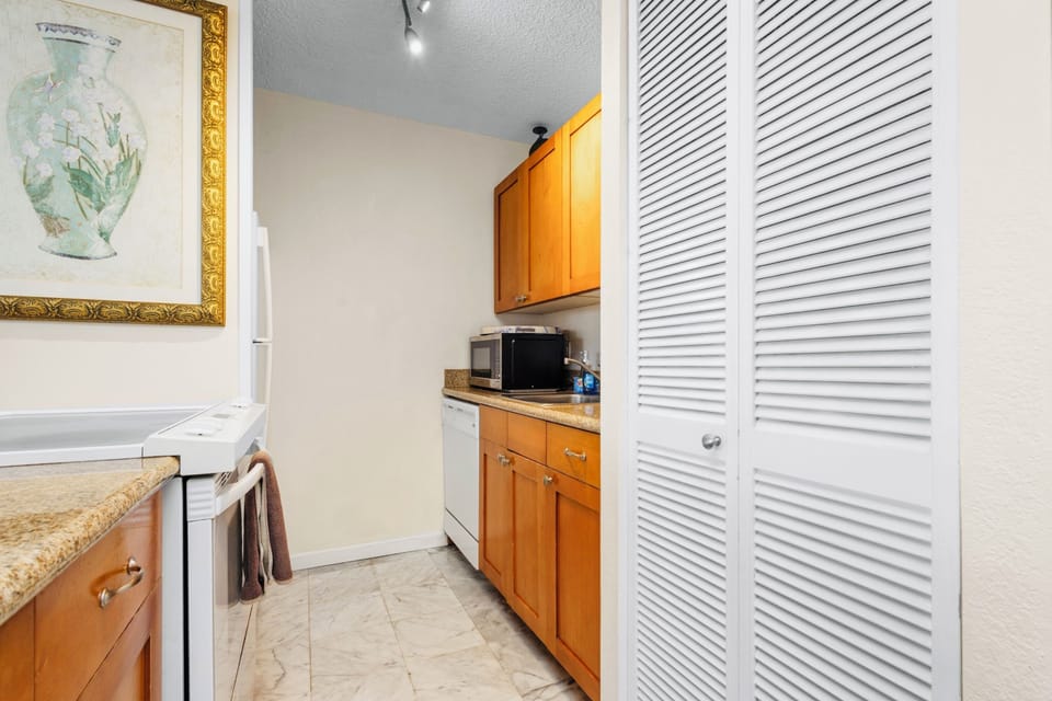kitchen area with washer dryer unit inside the shutter doors
