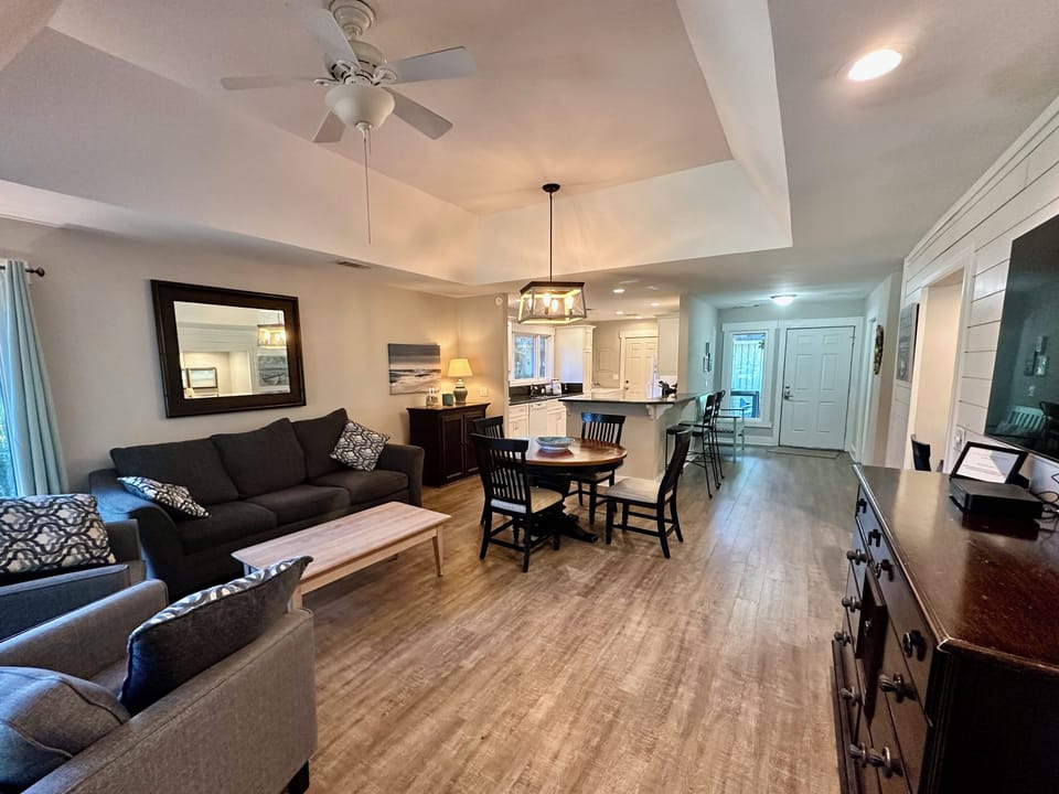 Living room with tray ceiling, ceiling fan, flat screen TV & golf views