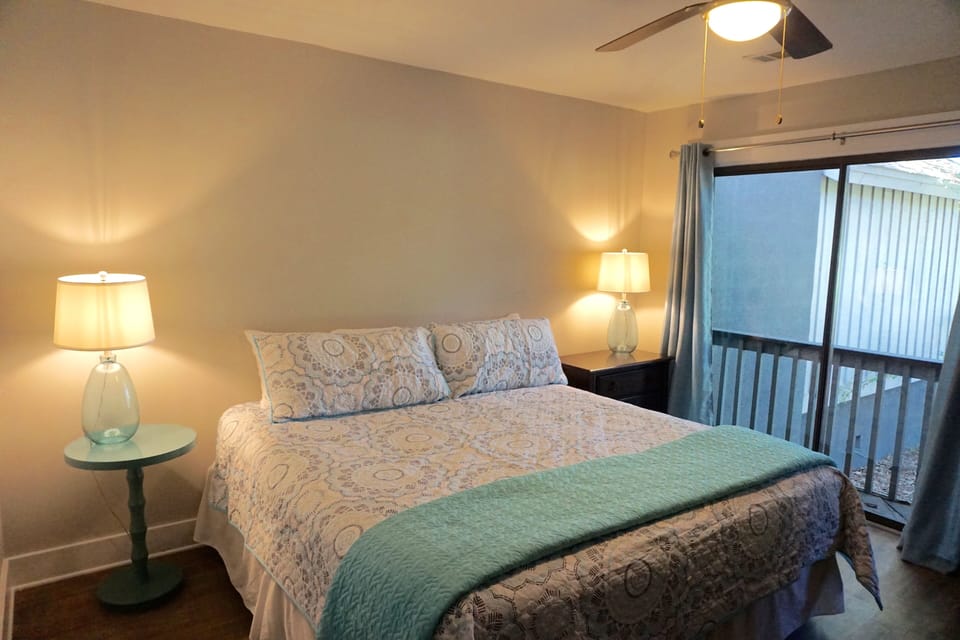 Master bedroom with king bed, flat screen TV, ceiling fan. Connects to porch