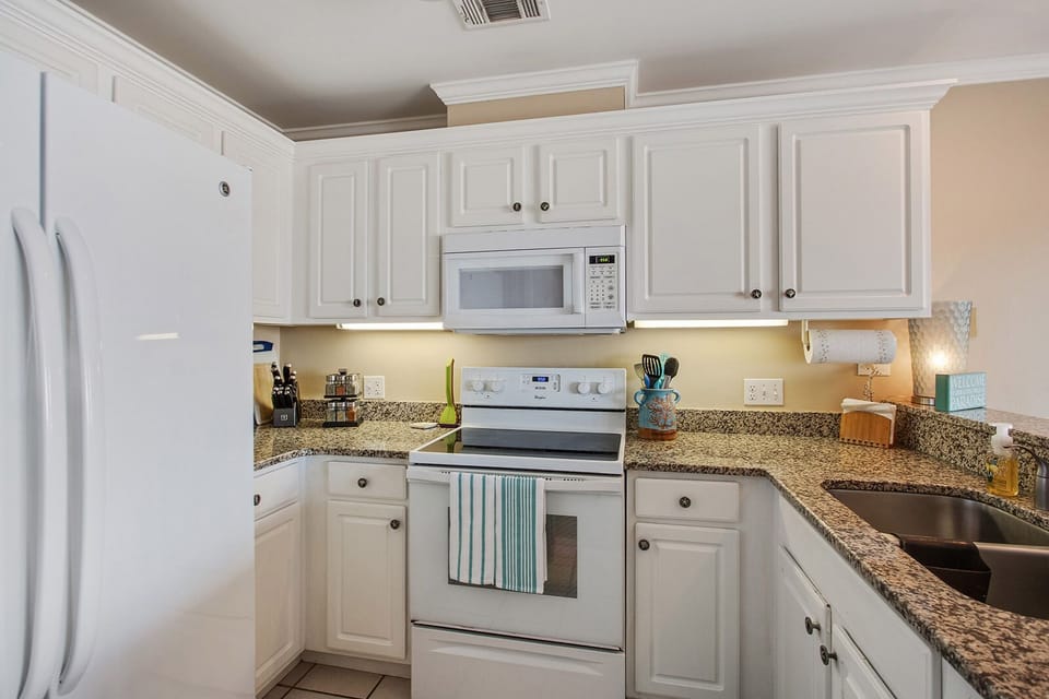 Fully equipped kitchen with dishes, utensils, pots & pans, dishwasher and spices