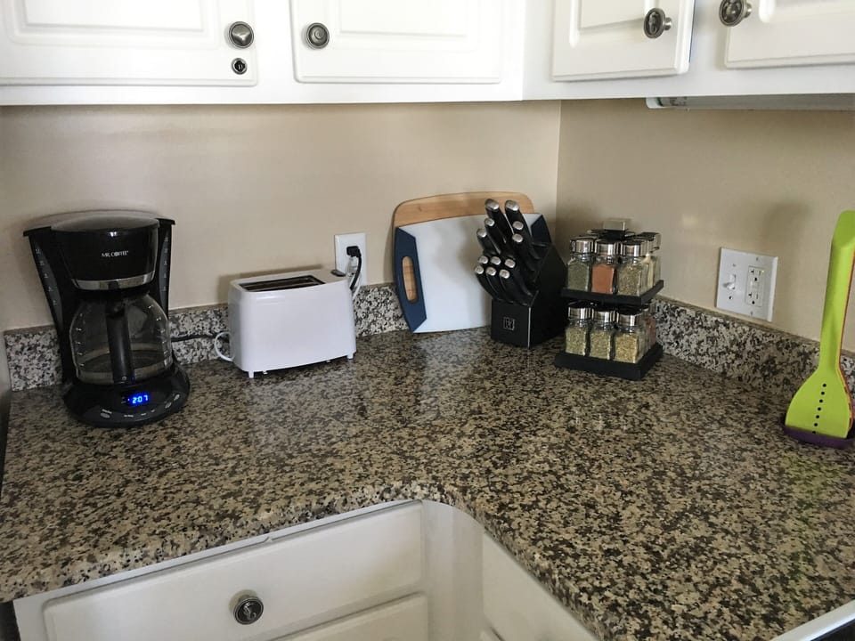 There is a drip coffee maker with filters, starter coffee, sugar and creamer.