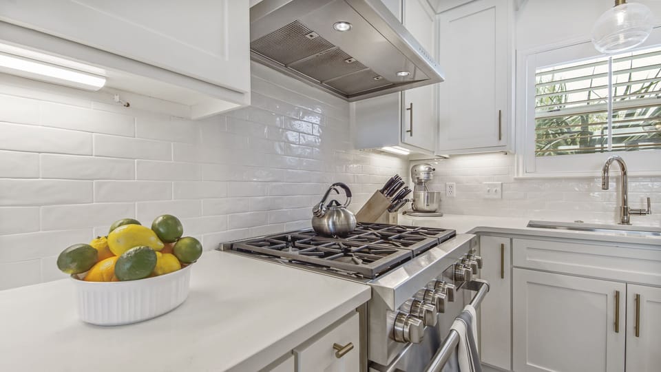 Kitchen features a 6 burner Wolf gas range and oven.