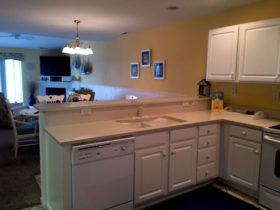 Solid sandstone countertops with white appliances.  Watch TV while cooking!