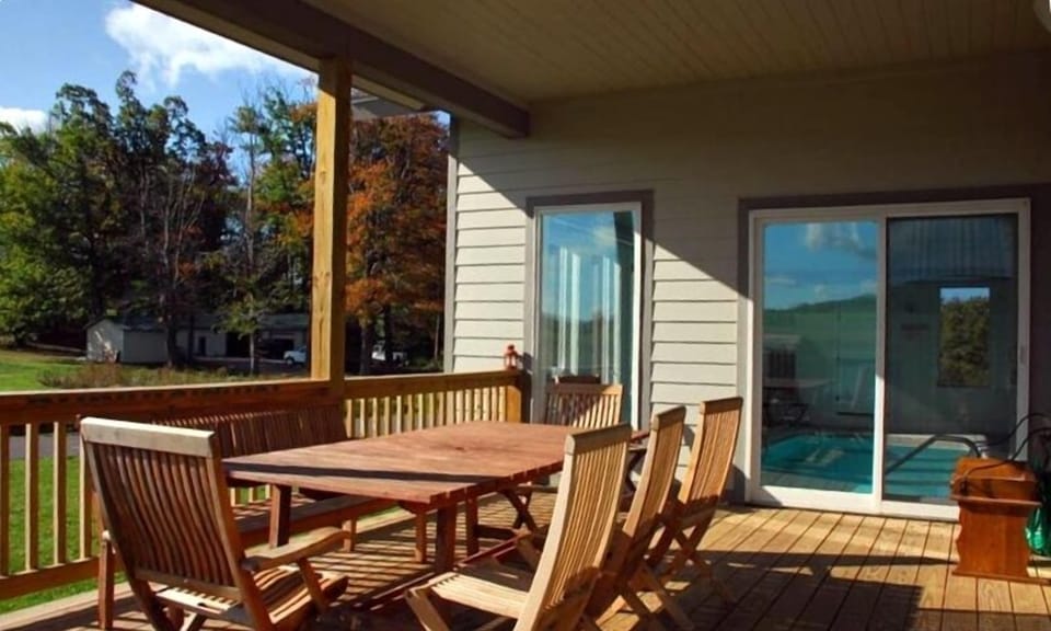 Covered deck with grill next to the pool overlooking mini golf & tennis courts