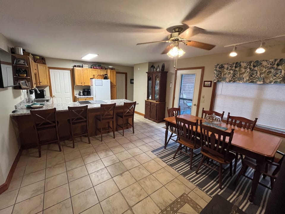 Open kitchen and dining area with table, chairs, and bar stools