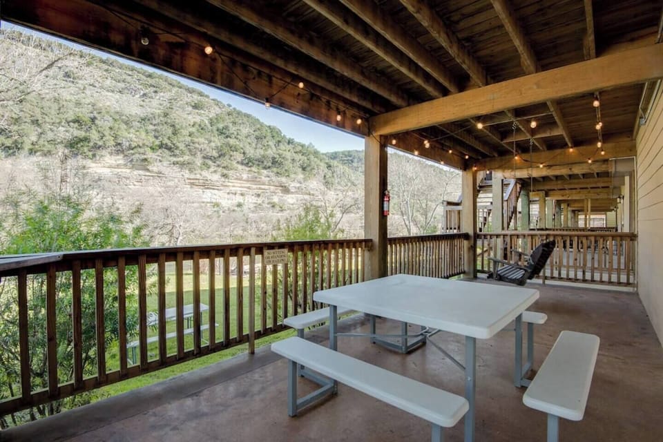 Porch swing and picnic table under the house with festoon lighting.