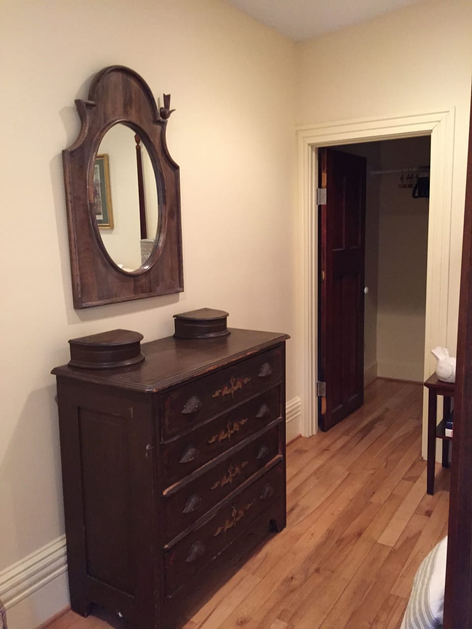 An antique dresser and whimsical mirror in the bedroom.