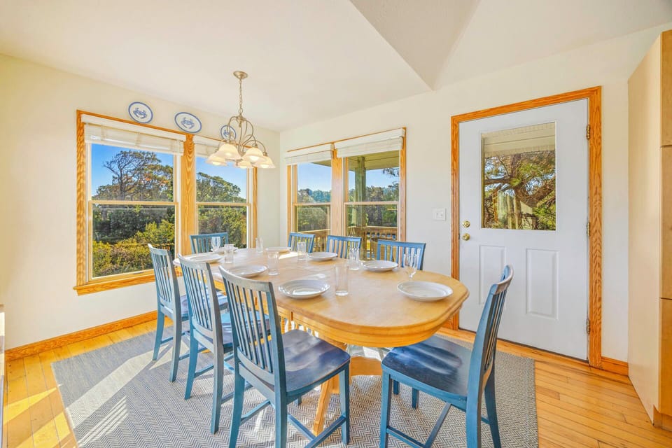 Gather around your spacious dining table with panoramic garden views streaming through oversized windows, creating the perfect backdrop for memorable meals.