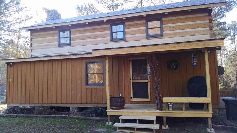 Back door with covered deck, gas grill and goldfish barrel.