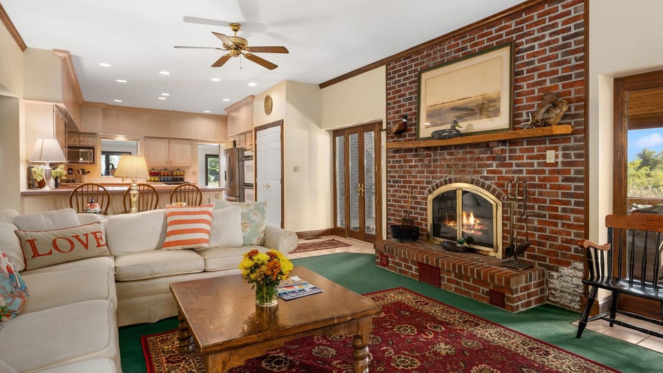 Fireplace works. SW screened porch is through French doors, to right.