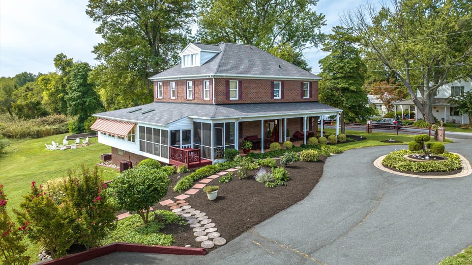 Sun room on left, NE screened porch, front porch. House fire pit in background
