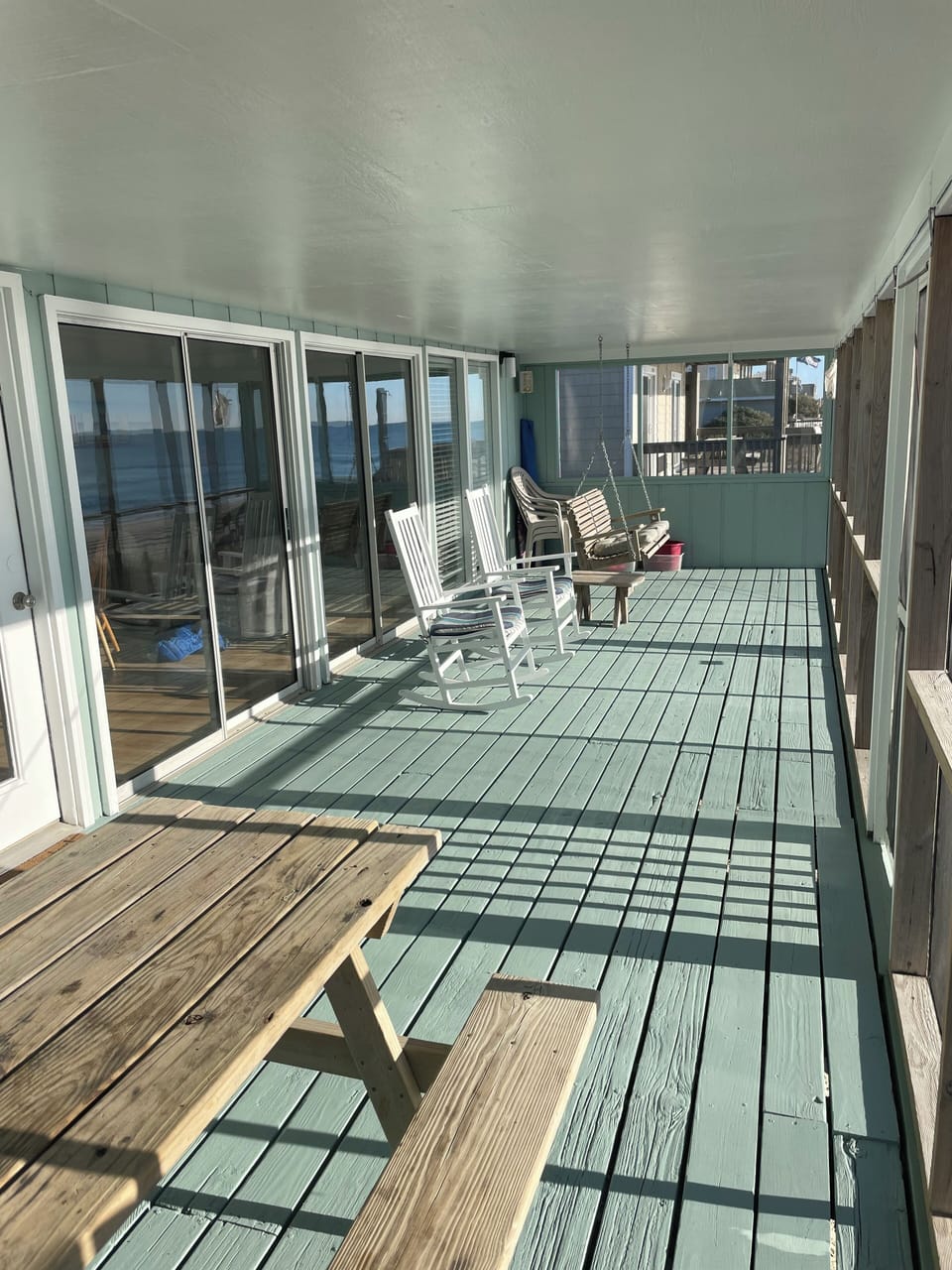 Oceanfront screen porch with picnic table, rocking chairs and porch swing