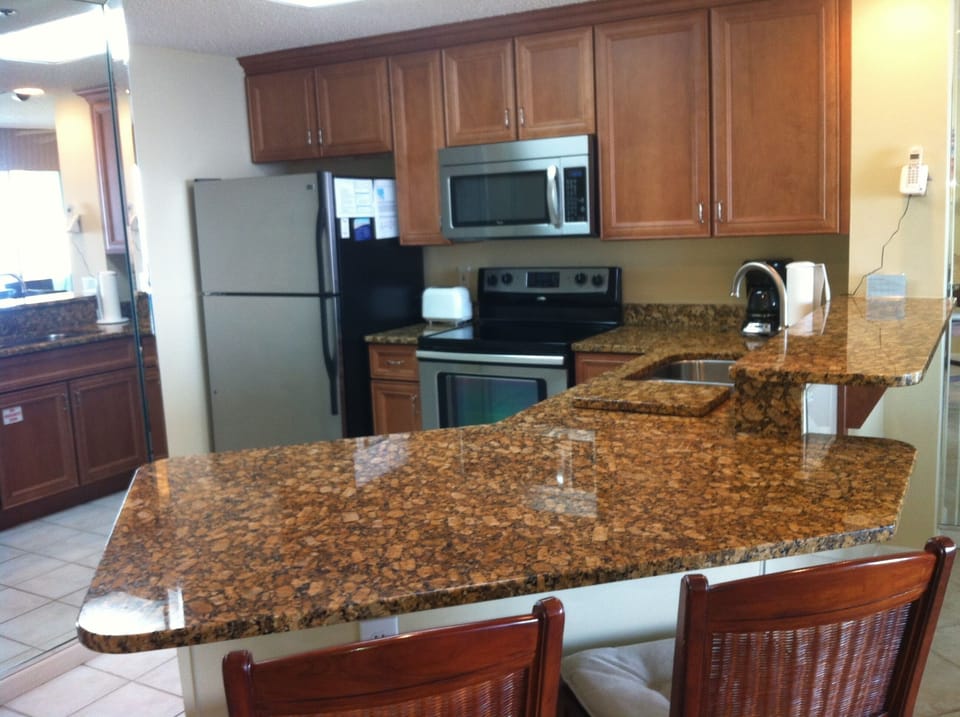 Fully equipped kitchen with stainless steel appliances and granite counter-tops 