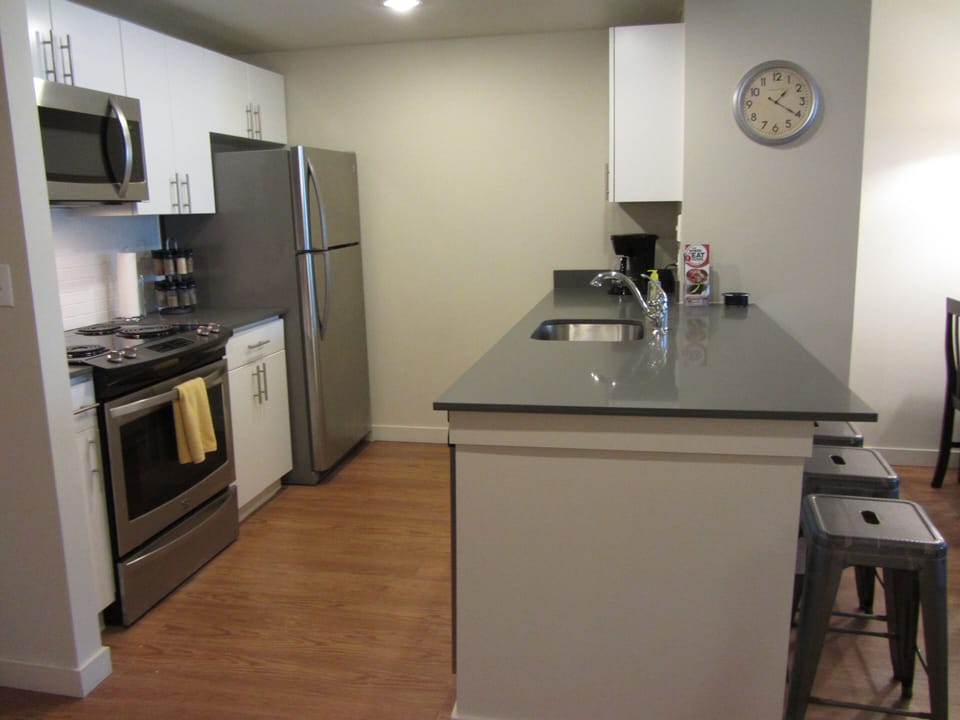 Beautiful remodeled kitchen with new white cabinets, gray quartz counter tops