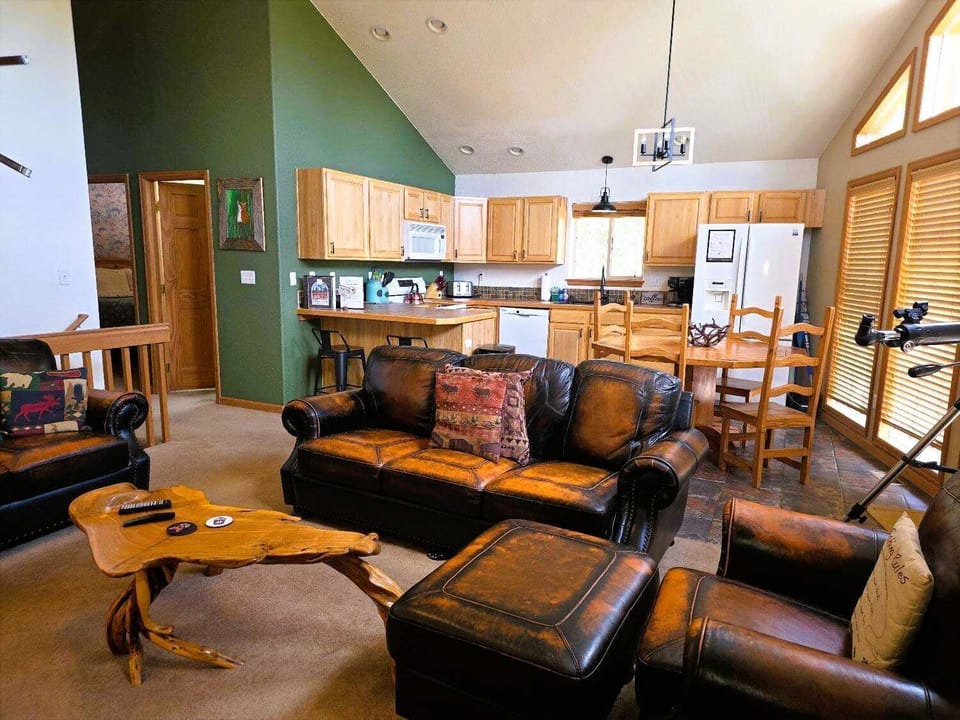 The living room with the comfortable leather furniture is all part of the Great Room with ceiling to floor windows.