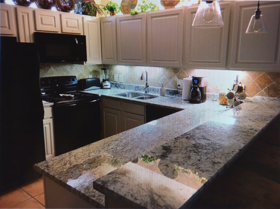 Newly renovated kitchen with granite counter tops and Edison pendant lights 