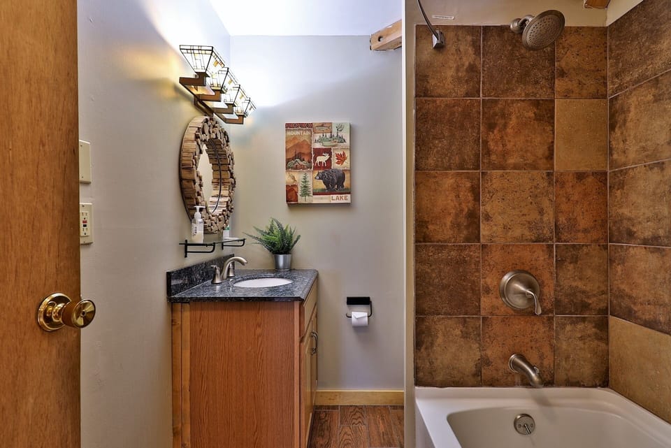 The vanity, mirror, toilet, and tub-shower are grouped into one efficient bathroom layout.