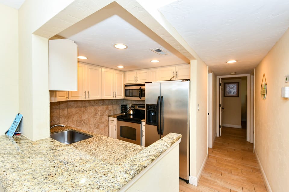 Modern, fully equipped kitchen with granite counters and all stainless appliances