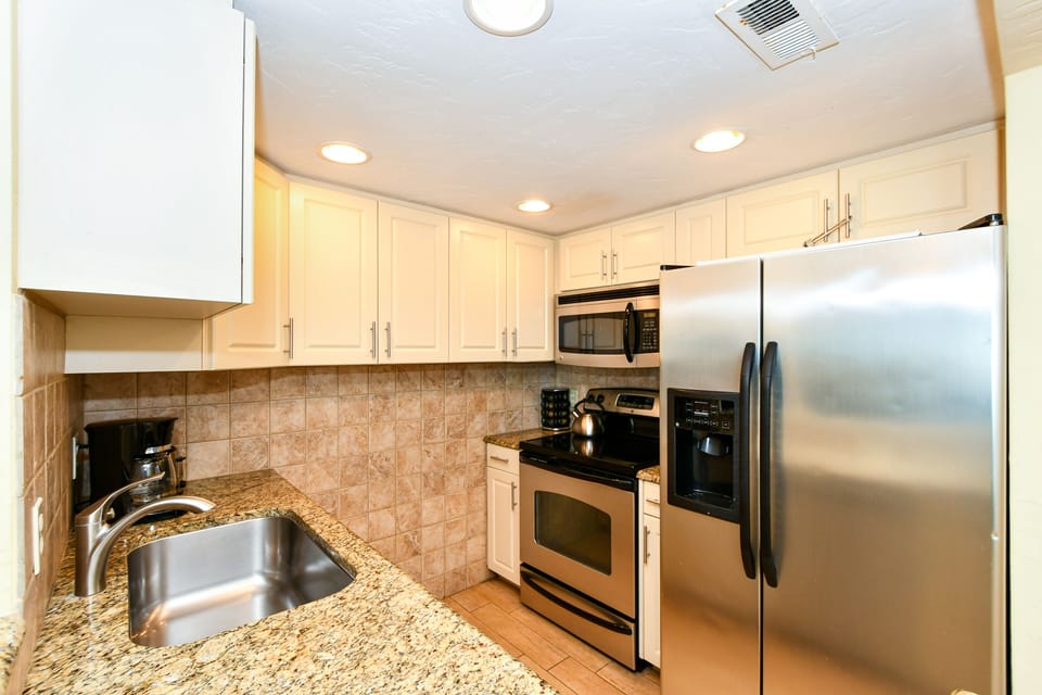 Modern, fully equipped kitchen with granite counters and all stainless appliances