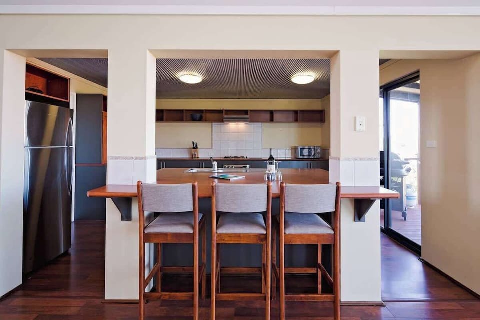  A well-equipped modern kitchen with a coffee machine and a central island bench for effortless meal prep and casual bites.