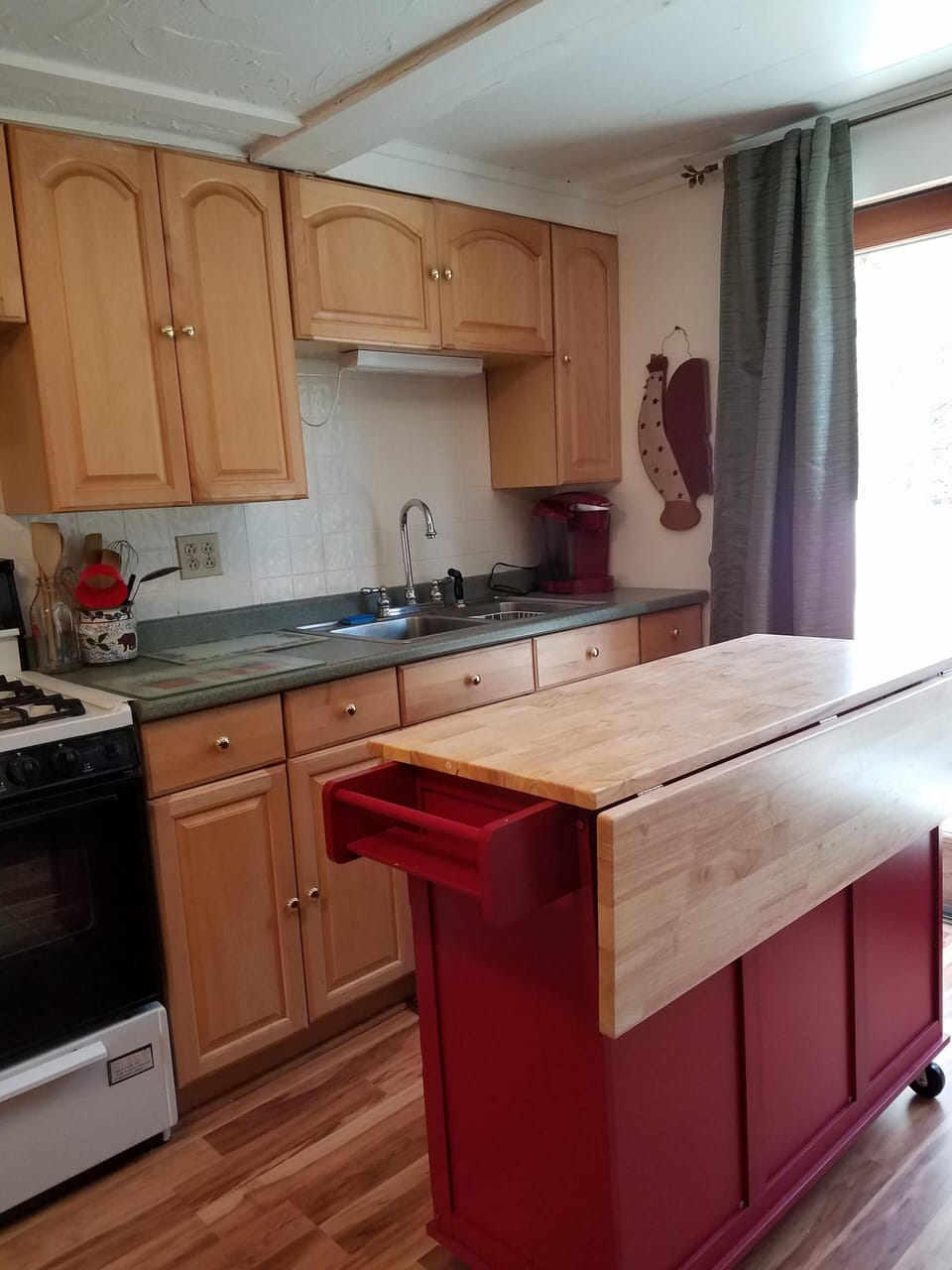 Well-stocked kitchen area with moveable island for convenience.