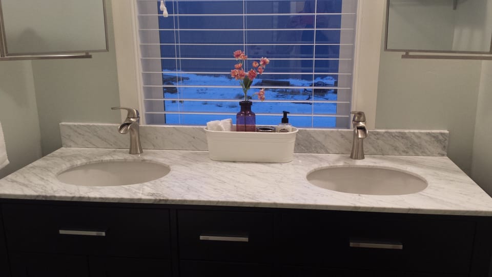 Bathroom has toilet, tub/shower and slate floors.