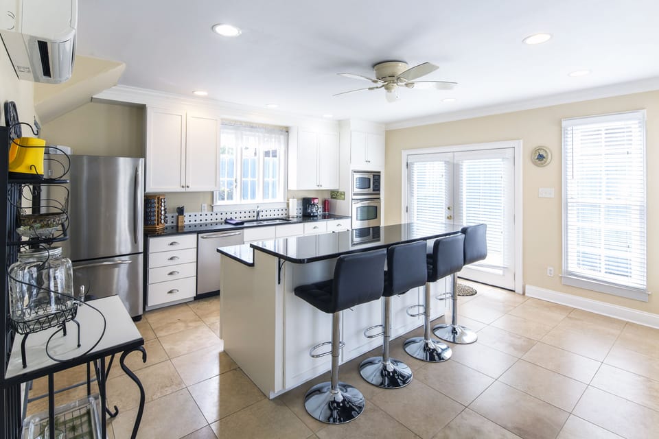 Spacious well-equipped kitchen features  breakfast bar and  french doors. 