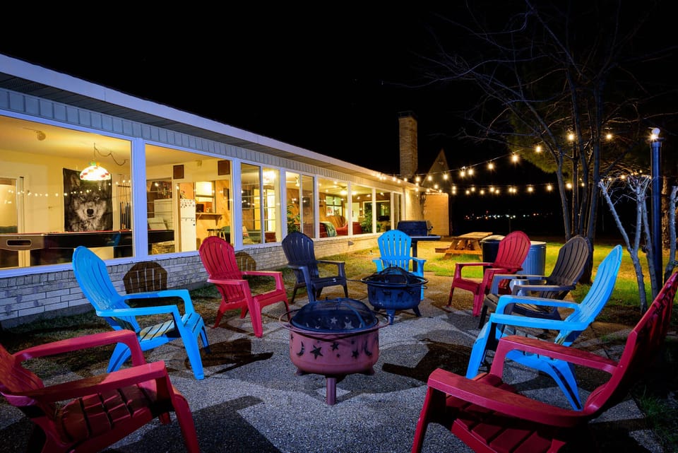 Fire pit and grill area with view of game room and pond. 