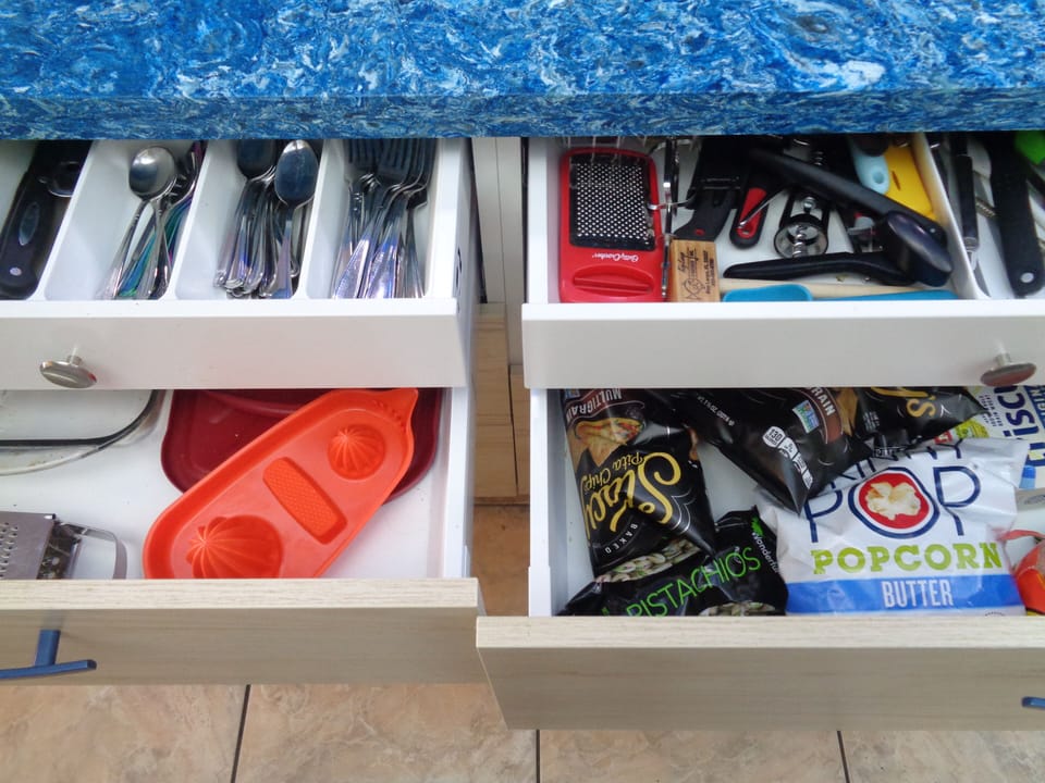 Space saving drawers and cabinets hold an array of utensils, and pots and pans.