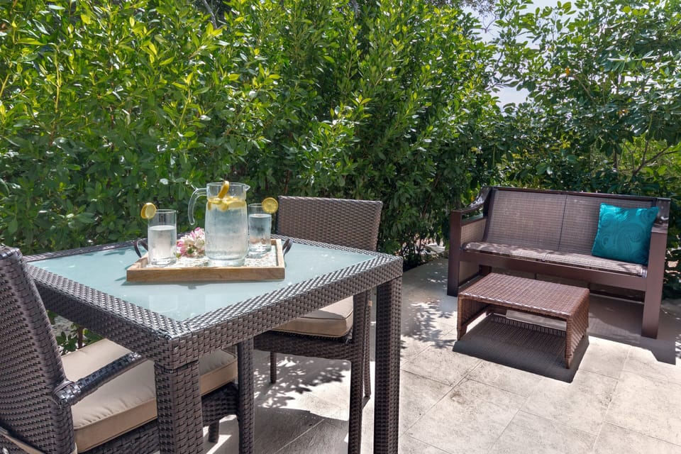 Relax and unwind on the exterior patio, furnished with a comfortable sofa, a table, and chairs, creating the perfect setting for outdoor enjoyment and leisurely moments