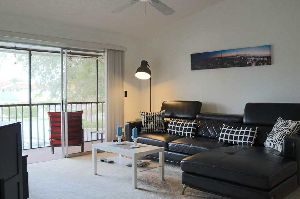 SUMW13 - Living with flat screen TV and sliding doors opening to the large screened in balcony.