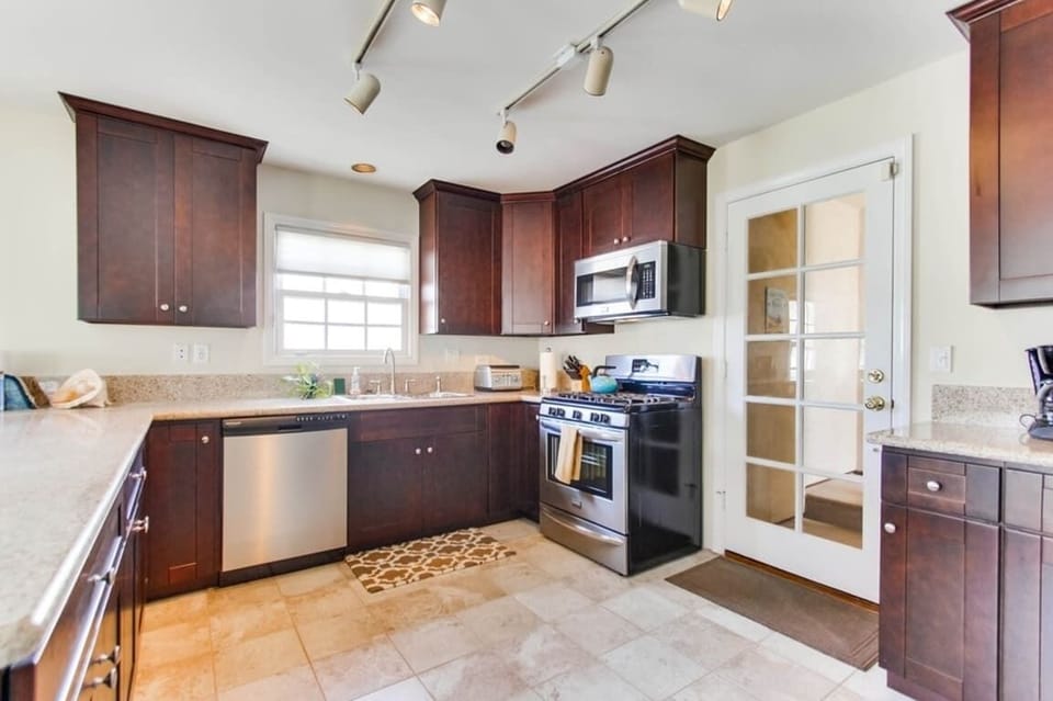 Entrance to open style kitchen with stainless steel appliances, recessed lighting, wood cabinets, toaster, sink, blender, dishwasher, coffee maker