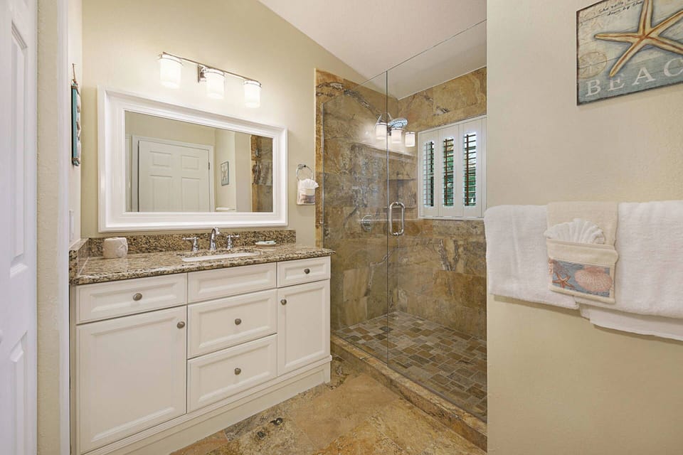 A clean, spacious glass walk-in shower and vanity — the guest bath keeps things simple and comfortable.