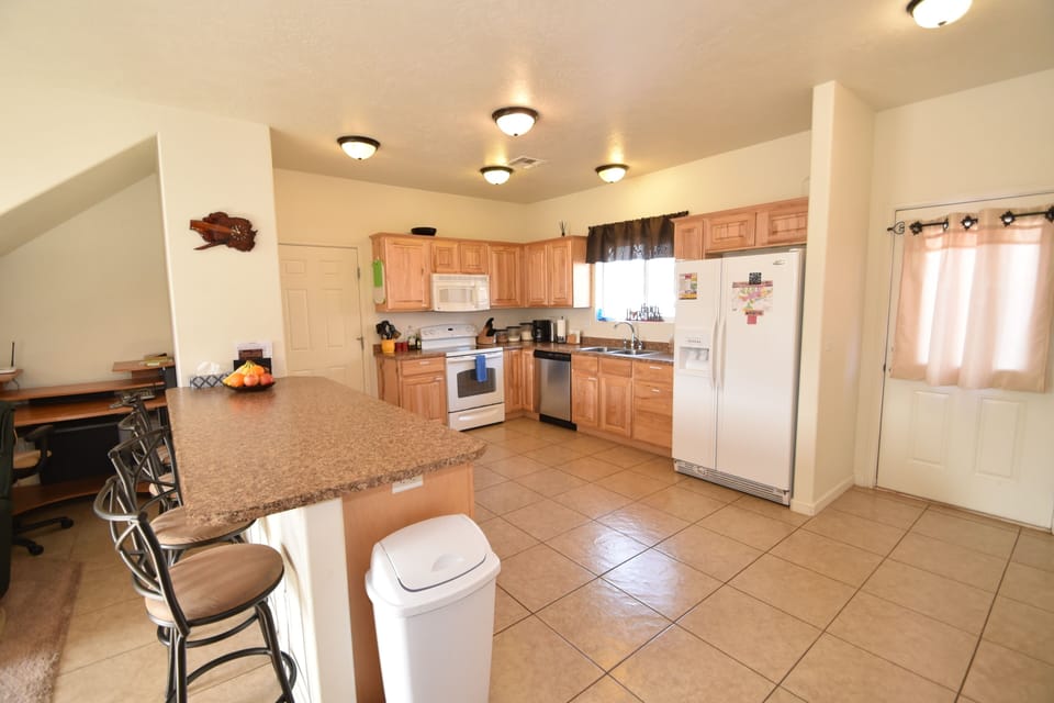Kitchen with range, microwave, dishwasher, fridge, small appliances.