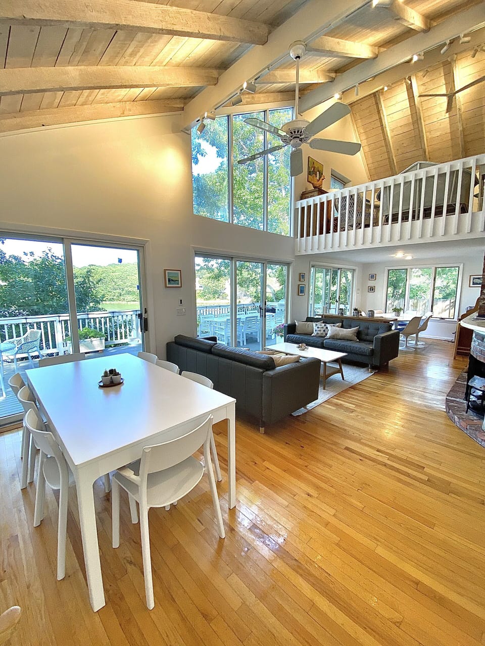 The great room includes 2 dining tables and abuts the kitchen and upper deck.