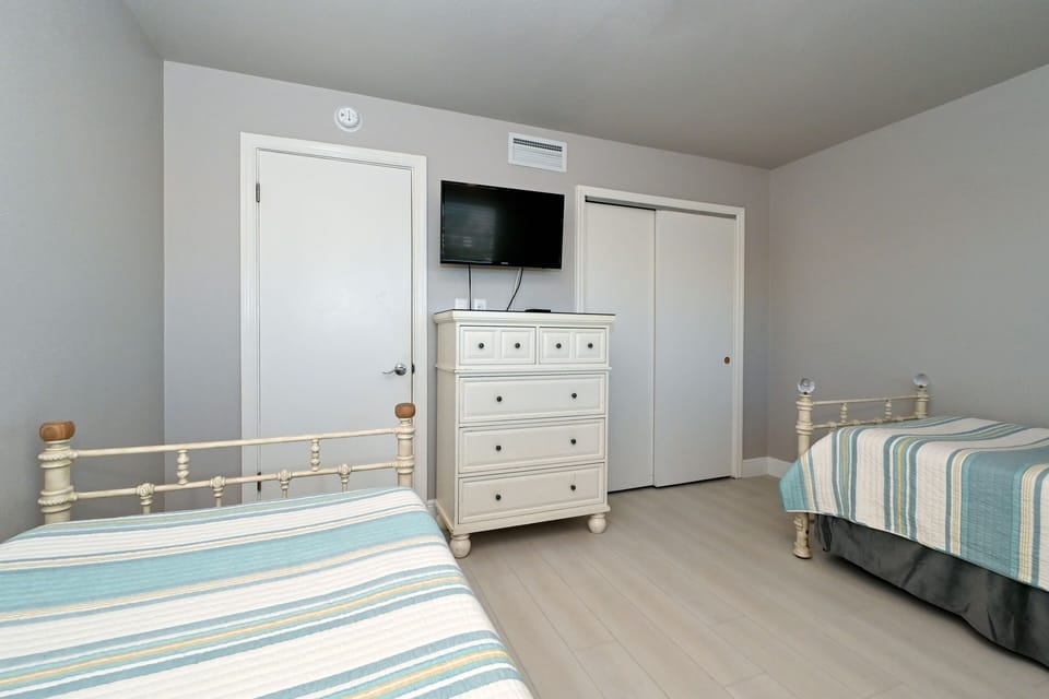 3rd bedroom with two twin-size bed, HDTV, large window overlooking the bay and boat docks