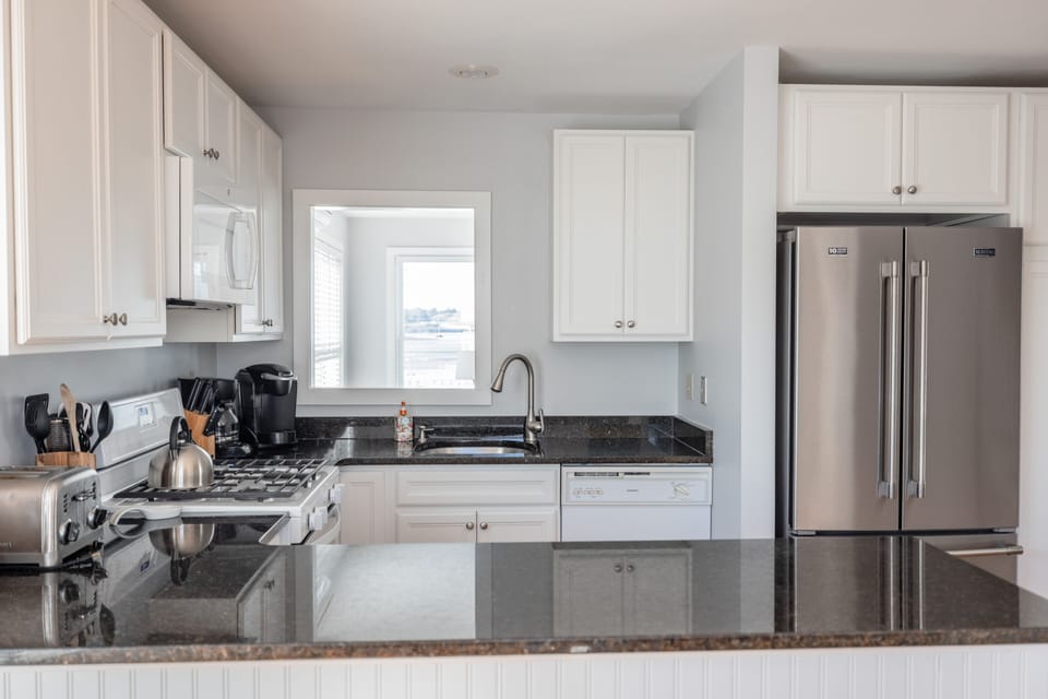 Galley area of kitchen with stainless appliances, gas air fryer stove
