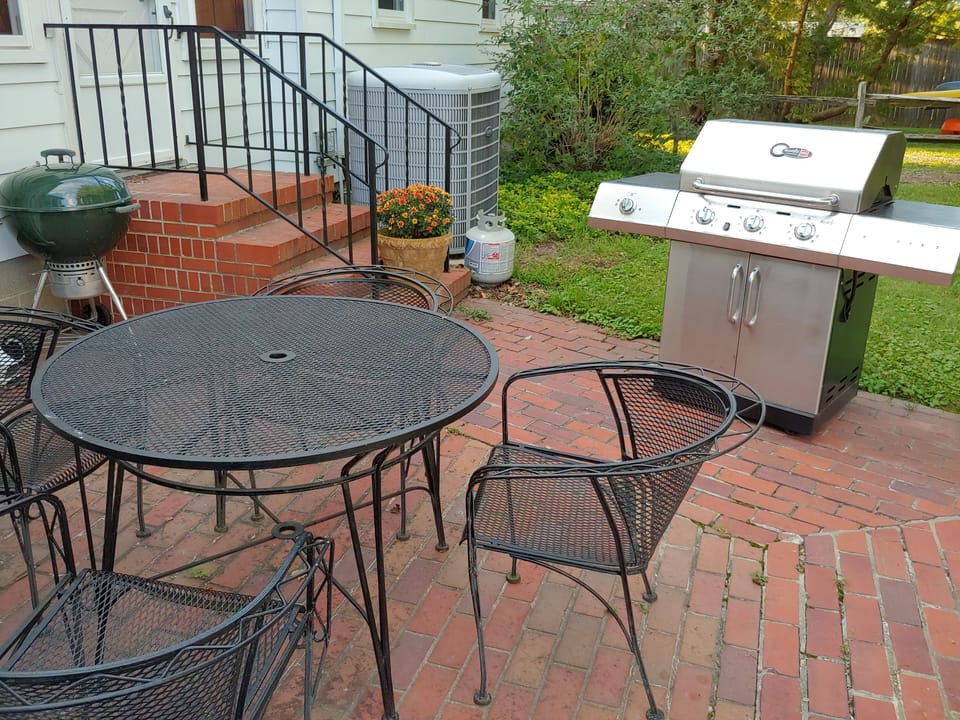 Charcoal grill and gas grill on the patio by the kitchen door.
