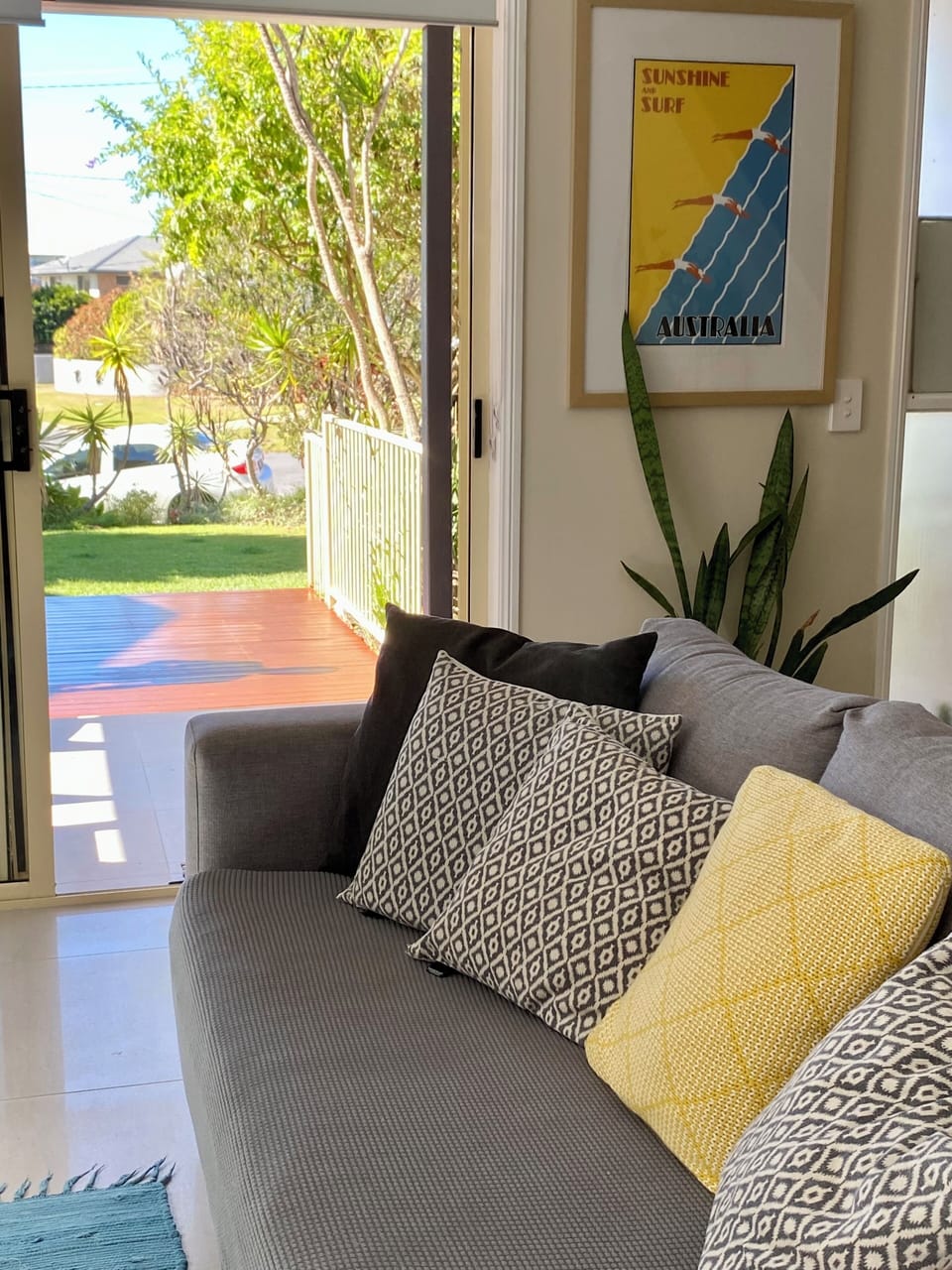 Lounge room leads out to front deck including daybed and outdoor table setting