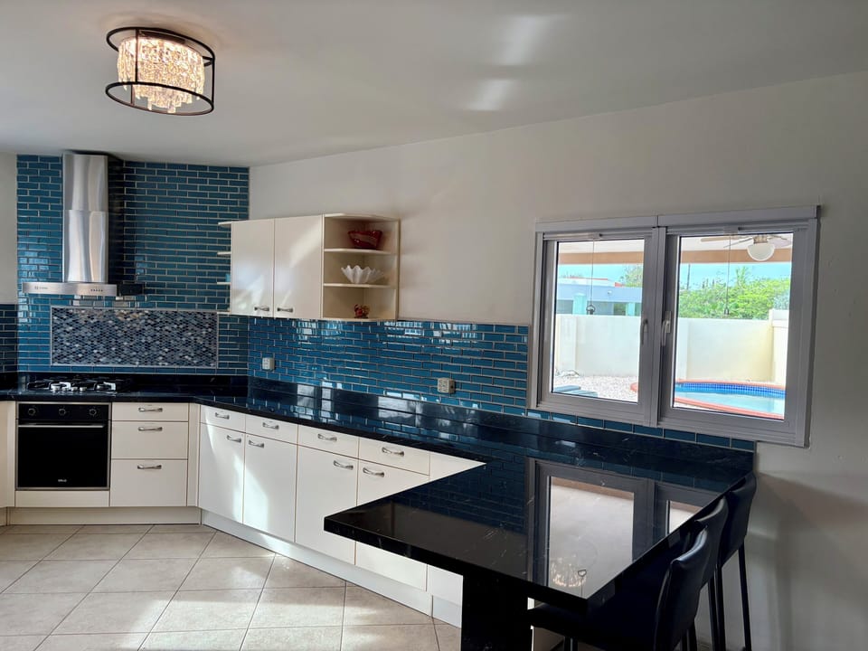 This spacious kitchen has a nice view overlooking the pool.