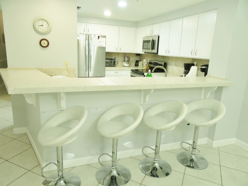 Newly painted grey walls complement the white cabinets and barstools nicely!