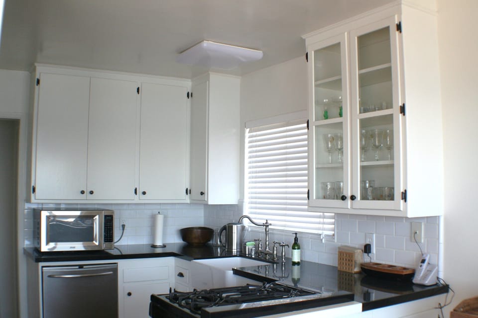 Fully equipped kitchen is accented with glass cabinetry and dishwasher