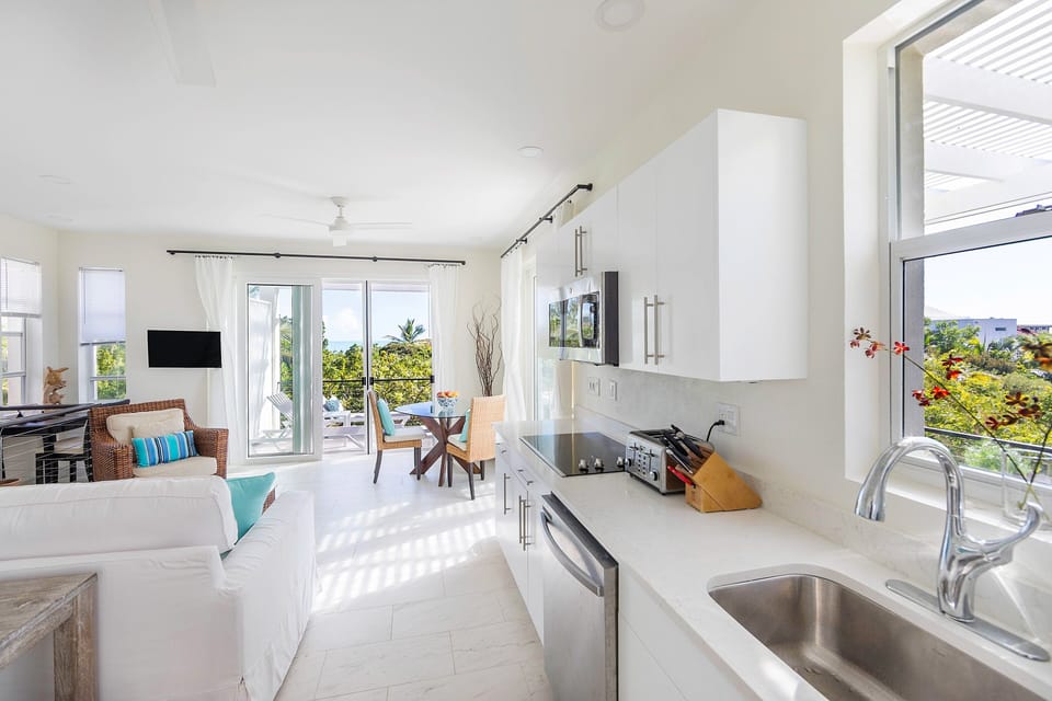 Unwind in the expansive living room and kitchen area of our residence, featuring a charming dining area that invites you to savor meals while delighting in the panoramic ocean view from the balcony