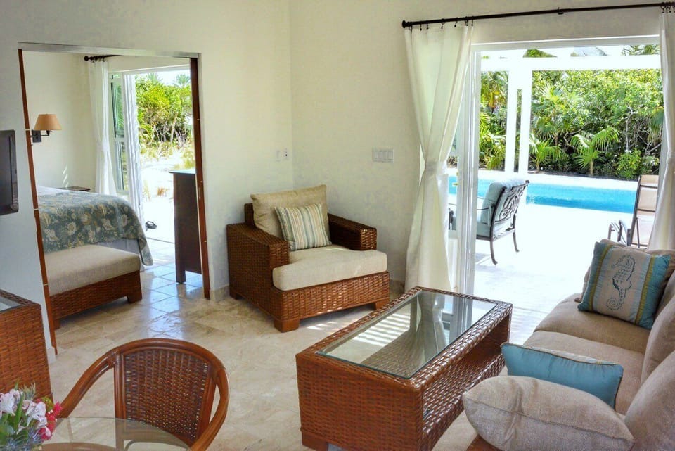 The living room seamlessly opens up to both the pool area and the bedroom, creating a harmonious flow throughout the space