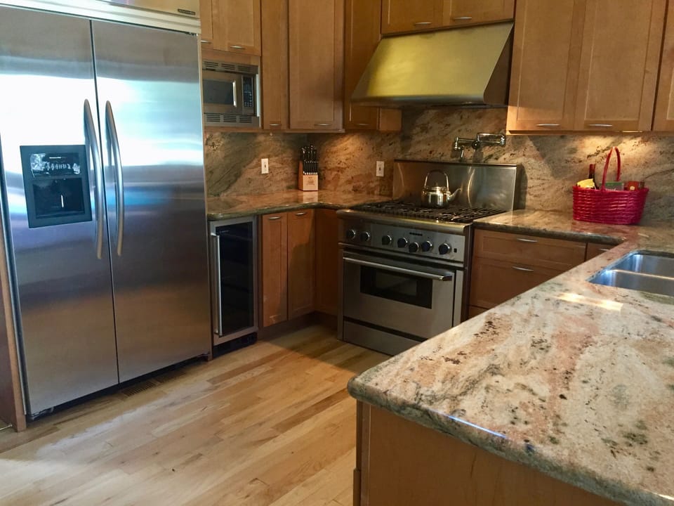 Gourmet kitchen. Granite countertops, stainless steel appliances + wine fridge