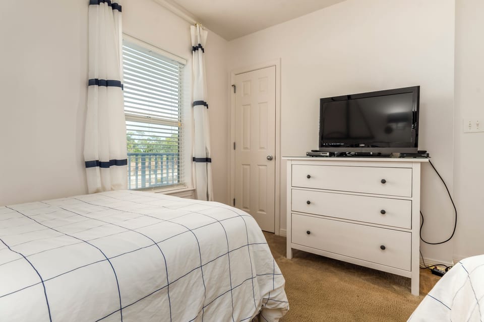 Drift off to sleep in this peaceful bedroom with soft linens and your own entertainment center for cozy evenings.